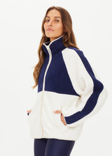 THE UPSIDE women’s white and navy Harlow Zip Through Jacket made with double sided recycled fleece features a full zip with contrasting mocha binds, white and navy colour blocks, and elastic at waist and cuffs