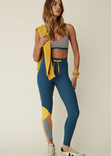 THE UPSIDE women’s blue mid-rise 25 Inch Midi Pant made with Recycled Peached fabric features a colour-block panelled sun feature on one leg, contrasting yellow elastic drawcord through waist and moisture wicking properties