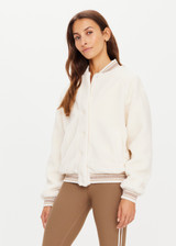 THE UPSIDE womens white varsity Banks Bomber jacket made with recycled sherpa features welt pockets, rib stripe detail at neck and cuffs and snap buttons.