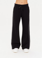 THE UPSIDE women's black Realm Jetset Pant made with soft suiting lenzing viscose fabrication features a straight-leg fit, functional front and back pockets, elastic waist with drawcord, cream piping details and tonal embroidered arrow on back pocket.