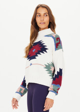 THE UPSIDE women's creme Pacha Clara Knit Crew made with 100% organic cotton chunky knit construction features a relaxed fit, high-neck and Pacha pattern design.