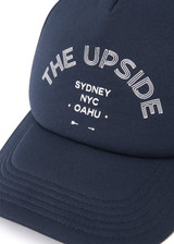 THE UPSIDE women's navy Jetset Trucker Hat is a classic trucker hat with a foam front and mesh back. This lifestyle hat features an adjustable snapper at the back.