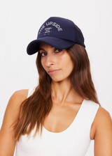 THE UPSIDE women's navy Jetset Trucker Hat is a classic trucker hat with a foam front and mesh back. This lifestyle hat features an adjustable snapper at the back.