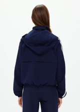 THE UPSIDE women's navy Mansi Dawson Run Jacket is made in a light and breathable recycled fabric, featuring colours of green and white. The run jacket is water resistant and is fitted with elasticated cuffs with inner sleeve gloves and invisible zip pockets and a large back pocket for storing purposes. Designed for golf.