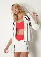 THE UPSIDE women's white Pacific Morgan Zip Jacket is made from organic cotton. The tennis jacket features pockets and drawstring. Designed for tennis and pickleball.