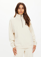 THE UPSIDE women's white organic cotton Hamilton Wren Half Zip Sweater is designed for a regular fit and features a embroidered horseshoe logo. Perfect for everyday.