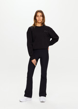 THE UPSIDE women's black Peached Florence Flare is a high-rise full length flare pant with V waistband and a printed arrow logo on back waistband.