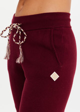 THE UPSIDE women’s maroon organic cotton Le Ski Jojo Knit Jogger features a soft knitted waistband with braided tassel drawcord, side pockets and snowflake design at ankles. Designed for Après-ski and winter wear.