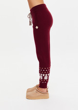 THE UPSIDE women’s maroon organic cotton Le Ski Jojo Knit Jogger features a soft knitted waistband with braided tassel drawcord, side pockets and snowflake design at ankles. Designed for Après-ski and winter wear.