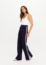 THE UPSIDE women's navy Monte Carlo Freya Knit Pant fits true-to-size and features an elasticated waistband with belt and knitted white side stripes. Made for lifestyle.