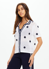 THE UPSIDE women's white organic cotton Piazza Koa Knit Shirt features a ribbed white collar with navy striped placket edge and pearlised shell button closure. Made for everyday.