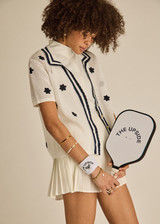 THE UPSIDE women's white organic cotton Piazza Koa Knit Shirt features a ribbed white collar with navy striped placket edge and pearlised shell button closure. Made for everyday.