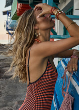 THE UPSIDE women's orange and navy check Solaris Flow One Piece features a scoop front neckline and low back with adjustable straps. Designed for swim.