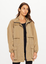 THE UPSIDE women's brown Rylan Anorak is relaxed fit, mid-length, made from tan wrinkled water-resistant fabric. Made for yoga & pilates.