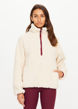 THE UPSIDE women's natural recycled polyester Harlow Fleece Pullover has a relaxed fit with a striped rib collar, contrast maroon stripes, and zip pockets. Made for lifestyle