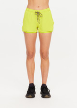 THE UPSIDE women's green recycled polyester Lucky Run Short is designed for a true-to-size fit and features a slightly curved hem with inner short for full coverage. Made for running.