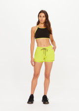 THE UPSIDE women's green recycled polyester Lucky Run Short is designed for a true-to-size fit and features a slightly curved hem with inner short for full coverage. Made for running.