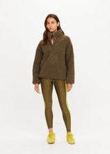 THE UPSIDE women's green recycled polyester Harlow Fleece Pullover is designed for a relaxed fit and features a quarter snap button opening and zip pockets. Made for lifestyle.