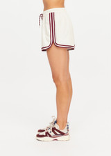 THE UPSIDE women's cream Klio Short is designed for a mid-rise, relaxed fit and features a soft elasticated waistband with drawcord and contrast binds in maroon along curved hem. Made for everyday.