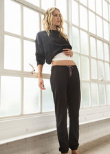 THE UPSIDE women's black organic cotton Kayne Track Pant is a classic mid-rise track pant and features a soft elasticated waistband with a brown paracord drawcord, elasticated cuffs and finished with a subtle embroidered arrow logo at back. The perfect everyday track pant, made to last.