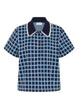 THE UPSIDE women's navy and blue plaid cotton Clubhouse Dom Polo Shirt is a relaxed fit and features a knitted collar with cream crochet detailing on edge. Made for tennis, golf & pickleball.