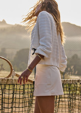THE UPSIDE women's cream Jolie Isabeli Knit Cardigan is a regular fit with a blouson sleeve crafted from a pointelle knit and features navy embroidered bows. Made for tennis, golf & pickleball.