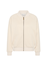 THE UPSIDE women's cream Navar Isabella Bomber Jacket is an oversized fit with raglan sleeves in our castilla "TU" design and features a front patch pocket, crafted from a knitted jacquard fabrication. Made for everyday wear.
