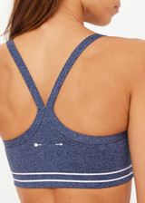 THE UPSIDE women's blue Bowery Baxter Tbar Sports Bra features a scooped neckline with ultraflex recycled fabrication, removeable bust cups and cream embroidered stripes at underbust. Made for yoga & pilates.