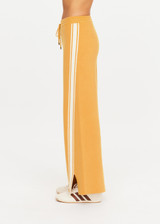 THE UPSIDE women's yellow organic cotton Bonito Moby Knit Pant is designed for a soft and supportive fit and features a high rise waist, side stripe detailing and adjustable drawcord. Made for lifestyle.