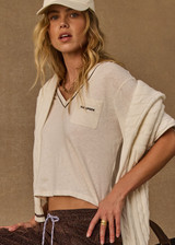 THE UPSIDE women’s natural Elina V Neck Tee is a boxy-fit style featuring a mini chest patch pocket and ribbed neckline with chocolate piping. Made for lifestyle.