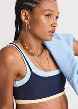 THE UPSIDE women's navy recycled nylon Hermosa Ava Double Layer Bra is mid coverage and features a scooped neckline and contrast elasticated underbust  in butter. Made for yoga and pilates.