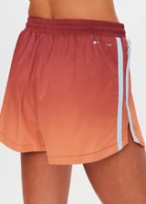 THE UPSIDE women's red recycled polyester Maya Billie Run Short is mid rise and features light blue mesh tape down side seams and side pockets. Made for running.