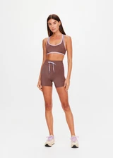 THE UPSIDE women's chocolate metallic Galaxia 4inch Spin Short is mid-rise and features a purple drawcord with aglets and purple rib binds down side seams. Made for yoga and pilates.