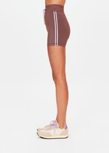 THE UPSIDE women's chocolate metallic Galaxia 4inch Spin Short is mid-rise and features a purple drawcord with aglets and purple rib binds down side seams. Made for yoga and pilates.