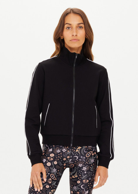 THE UPSIDE women's black slim-fit Realm Margot Jacket made with soft suiting lenzing viscose fabrication features a front zip, functional welt pockets at front, cream piping details, and rib neck, hem and cuffs.