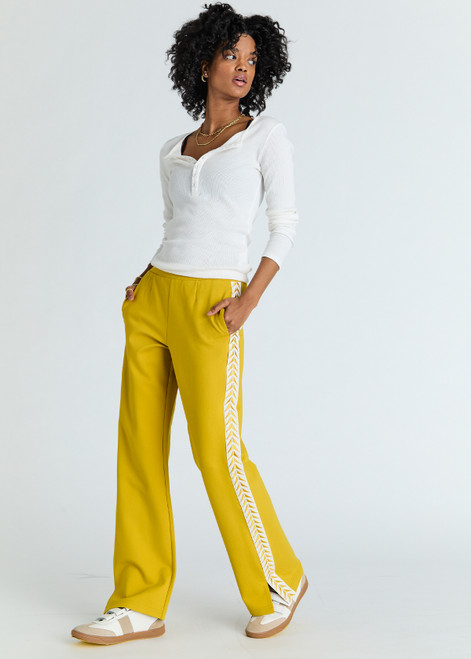 THE UPSIDE women's honeycomb yellow Ren Petra Flare is a flared pant with splits at front, contrast tape down side seams cream tape down the side seams, pockets and elastic at waist.