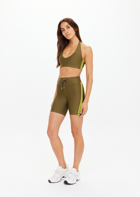 THE UPSIDE women's olive eco tech Oxford 5 Inch Spin Short is designed for a supportive and comfortable fit and features lime contrast binds and elastic drawcord. Made for high impact.