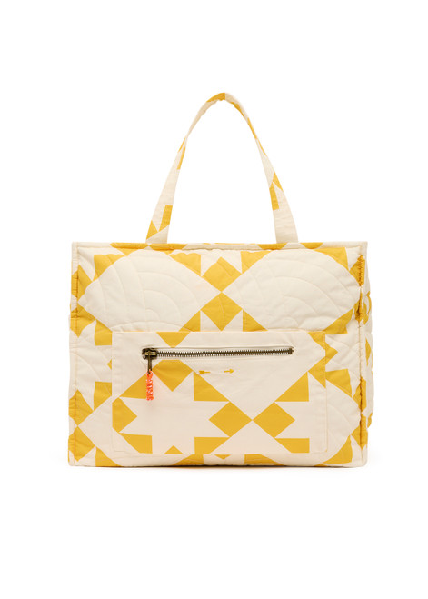 THE UPSIDE women's yellow large Etoile Quilted Tote Bag is designed in our star print and features a front external pocket with orange paracord zip pullers. Perfect for travel days.