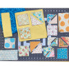 Garden Variety Pinwheel Star Quilt Kit fabrics in yellow, aqua, and floral prints