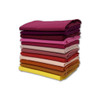Stack of Warm Solids fat quarters in burgundy, pink, orange, and yellow