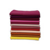 Folded stack of Warm Solids fat quarters in burgundy, coral, orange, and gold