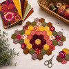 Warm Colors Quilter's Muse bundle shown as a hexagon mat in red, orange, gold, and brown