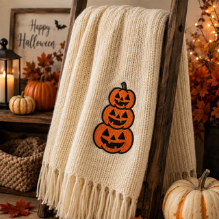 Stacked jack-o-lantern embroidery design stitched on a cream scarf