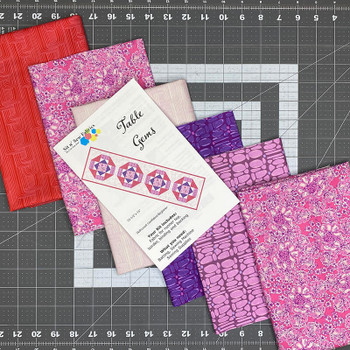 Table Gems table runner quilt kit fabrics with pattern card on cutting mat