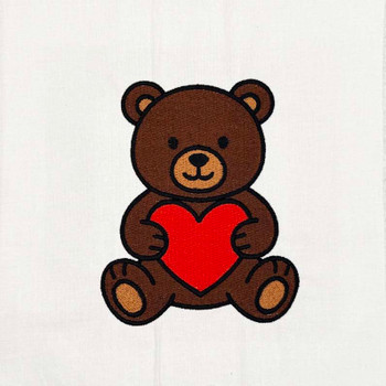 Teddy bear holding red heart machine embroidery design stitched in brown, red, and black on white fabric