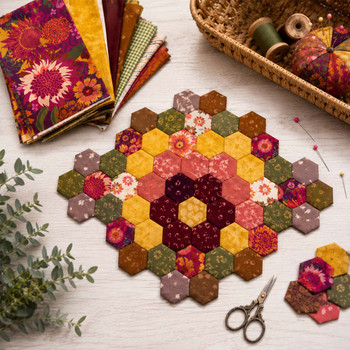 Warm Colors Quilter's Muse bundle shown as a hexagon mat in red, orange, gold, and brown