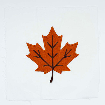 Orange autumn maple leaf embroidery with dark stitched veins