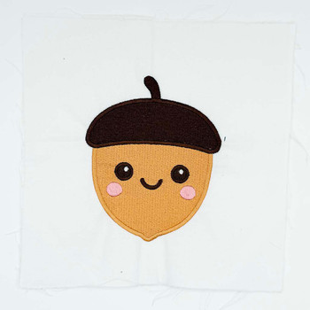 Cute smiling acorn embroidery with rosy cheeks