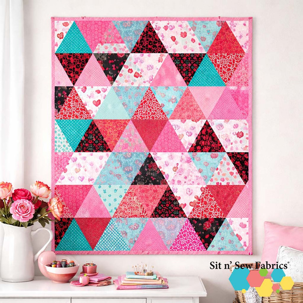 Triangle Love quilt with pink, red, and aqua triangle blocks shown as a finished quilt, AI-generated image.