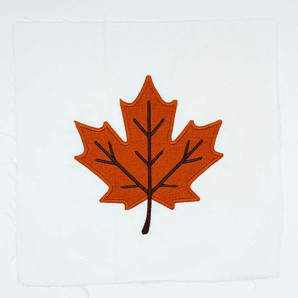 Orange autumn maple leaf embroidery with dark stitched veins